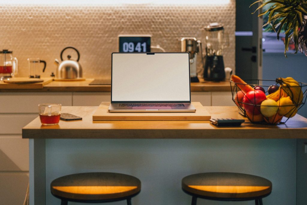 Laptop auf Küchentisch mit Obst
